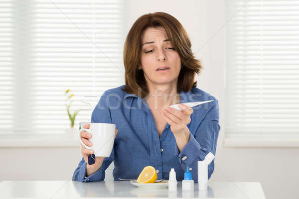 Sick Woman Looking At Thermometer Stock photo © AndreyPopov