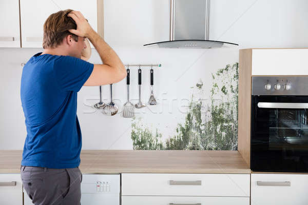 Hombre conmocionado joven pared cocina Foto stock © AndreyPopov