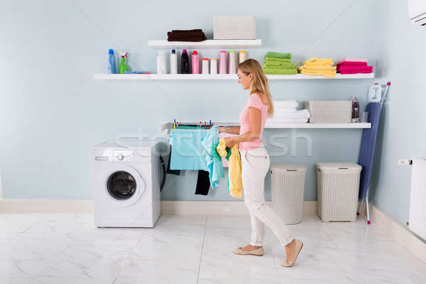 Woman Walking With Clothes In Utility Room Stock photo © AndreyPopov