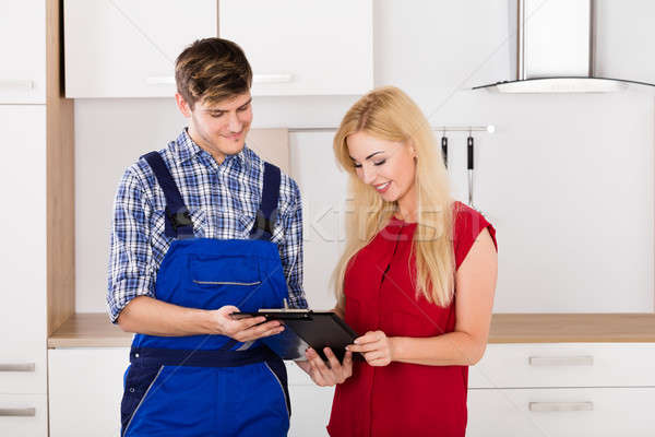 Stock photo: Woman Signing Invoice From Male Plumber