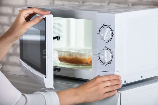 Kezek befejezés mikró sütő ajtó ételt készít Stock fotó © AndreyPopov
