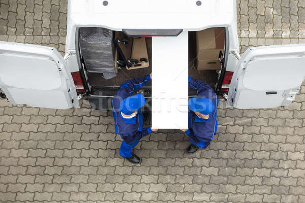 Two Delivery Men Unloading Furniture From Vehicle Stock photo © AndreyPopov