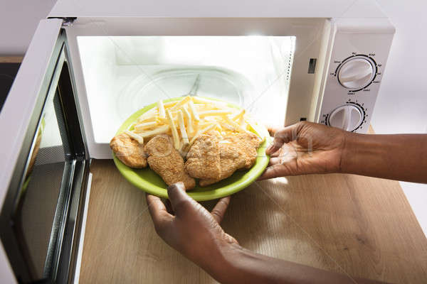 Person Heating Fried Food In Microwave Oven Stock photo © AndreyPopov