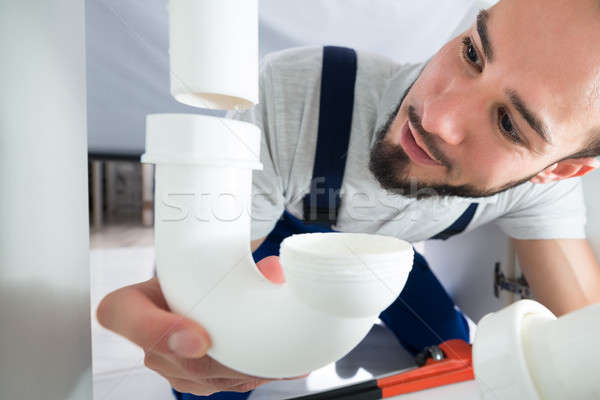 Vízvezetékszerelő kapcsolódik cső mosogató fiatal férfi Stock fotó © AndreyPopov