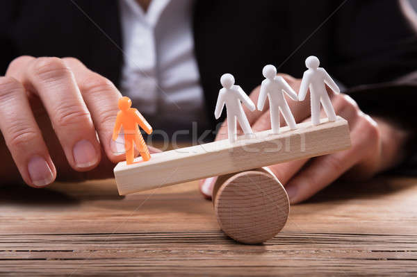 Close-up Of Orange Figure Against White Human Figures On Seesaw Stock photo © AndreyPopov