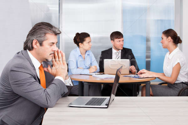 Túlhajszolt üzletember iroda laptop ül munkatársak Stock fotó © AndreyPopov