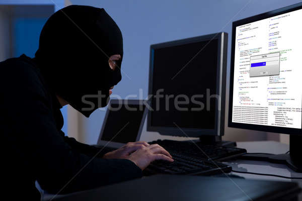 Hacker downloading information off a computer Stock photo © AndreyPopov