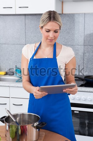 Stock photo: Woman Using Digital Tablet In Kitchen