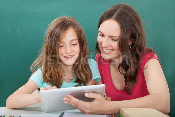 Woman Assisting Girl In Using Digital Tablet Stock photo © AndreyPopov