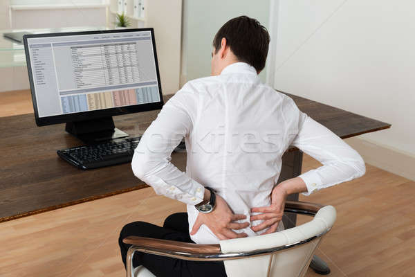 бизнесмен страдание боль в спине столе молодые сидят Сток-фото © AndreyPopov