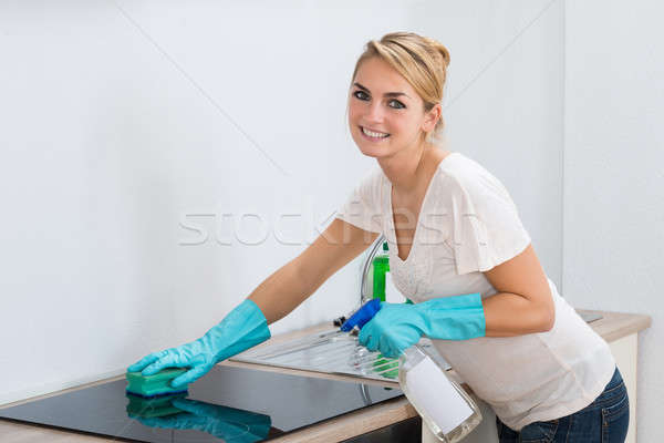 Confident Woman Cleaning Induction Stove At Home Stock photo © AndreyPopov