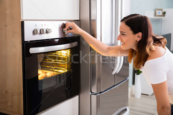 Vrouw magnetronoven oven keuken jonge vrouw Stockfoto © AndreyPopov