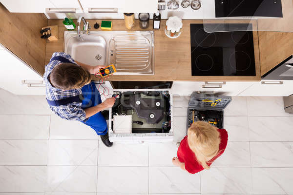 High Angle View Of Male Worker Repairing Washer In Kitchen Stock photo © AndreyPopov