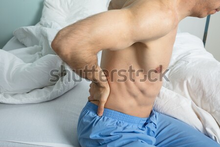 Hombre sufrimiento dolor de estómago sesión cama casa Foto stock © AndreyPopov