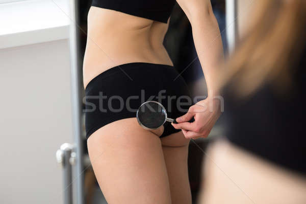 Reflection Of Woman Checking Her Buttock In Mirror Stock photo © AndreyPopov