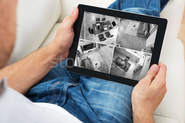 Man Sitting On Sofa And Monitoring Video Footage Stock photo © AndreyPopov
