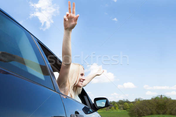 Young Woman Raising Hand Out Of Car Window Stock photo © AndreyPopov