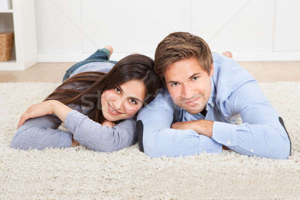 Happy Couple Lying On Rug In Living Room Stock photo © AndreyPopov