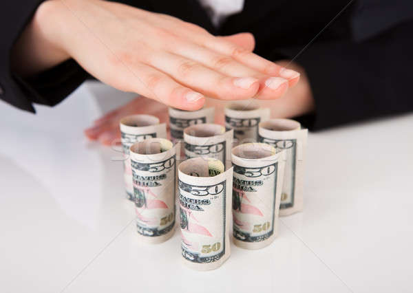 Businesswoman Shielding Rolled Dollar Bills Stock photo © AndreyPopov