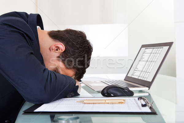 Tired Businessman Sleeping While Calculating Expenses In Office Stock photo © AndreyPopov