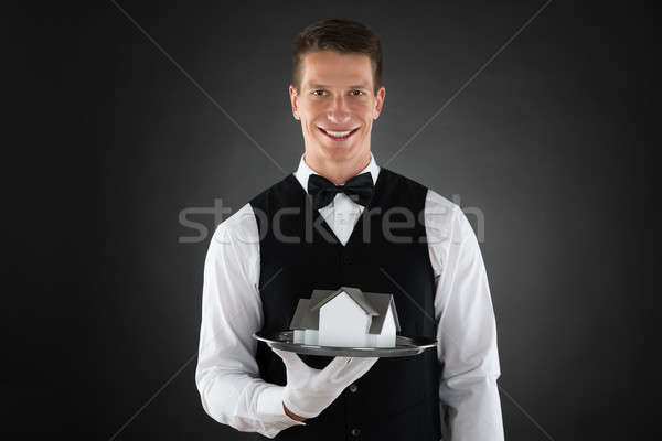 Waiter Holding Tray With Miniature House Stock photo © AndreyPopov