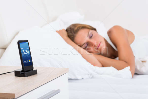 Mulher adormecido alarme telefone móvel mulher jovem cama Foto stock © AndreyPopov