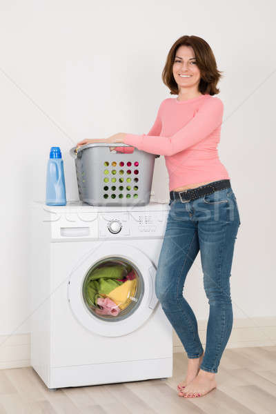 Jeune femme permanent machine à laver heureux détergent buanderie [[stock_photo]] © AndreyPopov