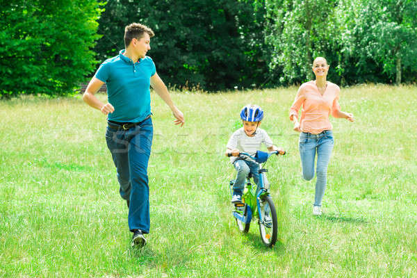 Ouders lopen zoon paardrijden fiets gelukkig Stockfoto © AndreyPopov