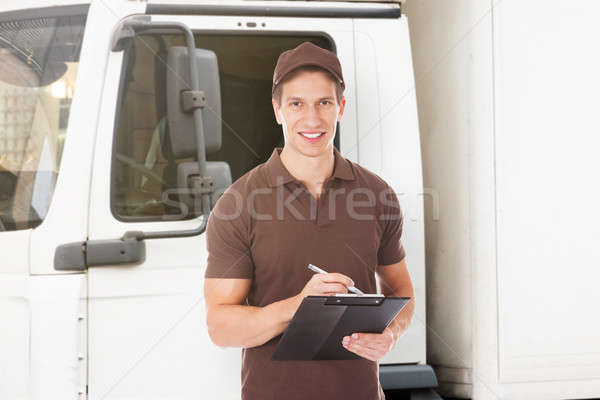 Smiling Delivery Man Holding Clipboard Stock photo © AndreyPopov