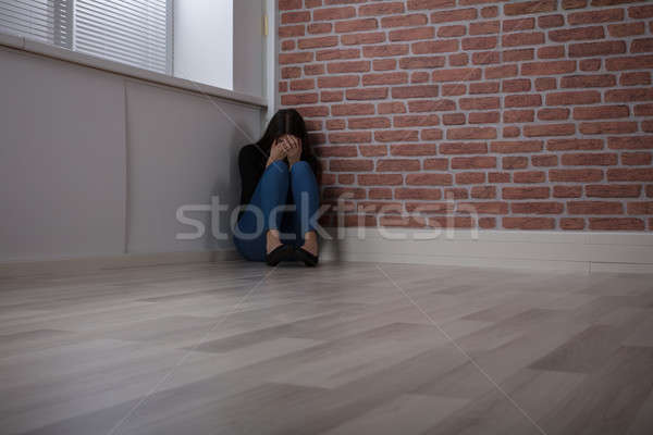 Feared Woman Sitting On The Corner Stock photo © AndreyPopov