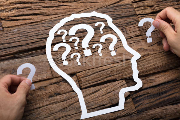 Stock photo: Businessman Holding Question Marks By Paper Head Outline