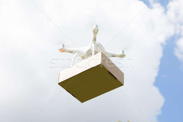 Stock photo: Drone delivering parcel against sky on sunny day
