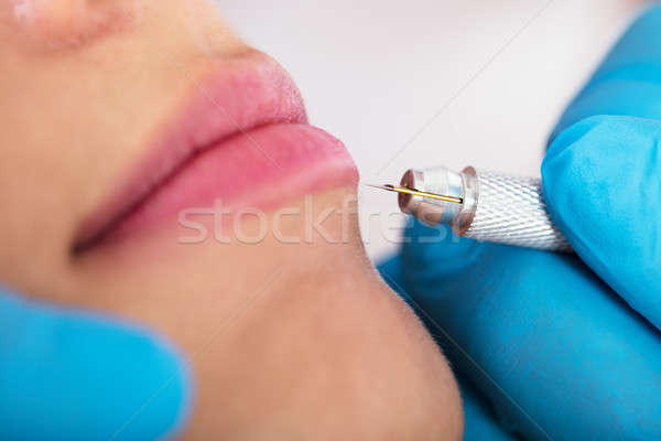 Cosmetologist Applying Permanent Make Up On Lips Stock photo © AndreyPopov