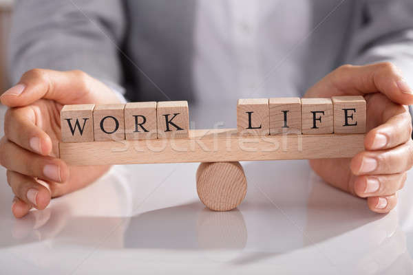 Businessperson Protecting Life And Work On Wooden Seesaw Stock photo © AndreyPopov