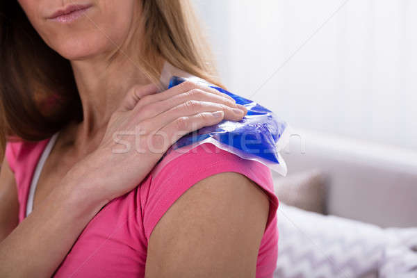 Woman Applying Ice Bag On Her Shoulder Stock photo © AndreyPopov