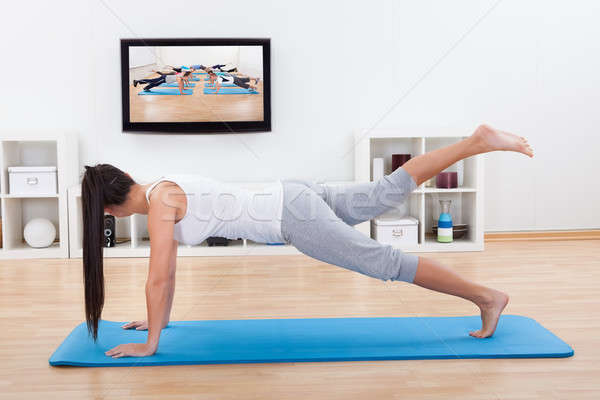 Woman practicing yoga at home Stock photo © AndreyPopov