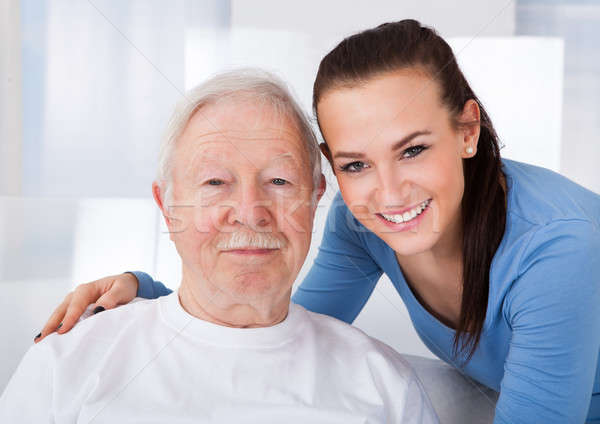 Caretaker With Senior Man At Nursing Home Stock photo © AndreyPopov