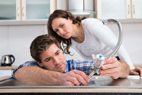 Femme regarder plombier acier robinet Photo stock © AndreyPopov