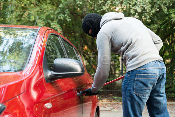 Thief With Mask Opening Car's Door By Crowbar Stock photo © AndreyPopov