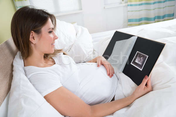 Stock photo: Pregnant Woman In Bed Looking At X-ray