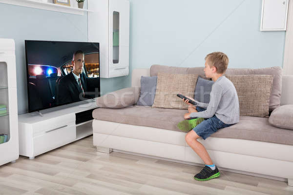 Boy with remote control in front of television Stock photo © AndreyPopov