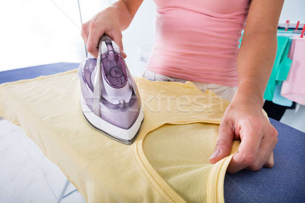 Woman Ironing Cloth With Electric Iron Stock Photo