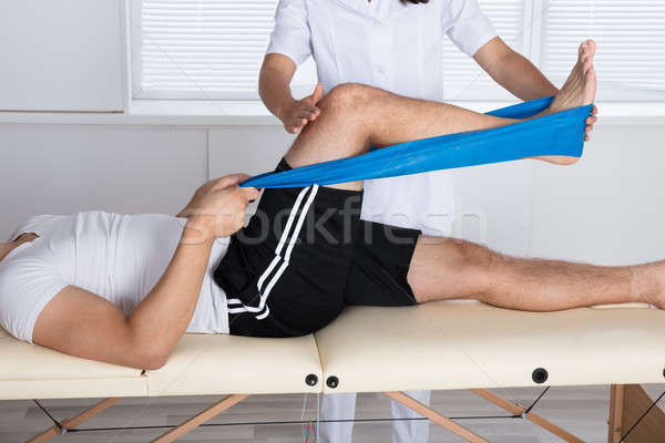 Physiotherapist Helping Patient While Exercising Stock photo © AndreyPopov
