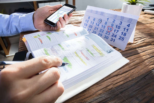 Businessperson's Hand Planning Schedule In Diary Stock photo © AndreyPopov