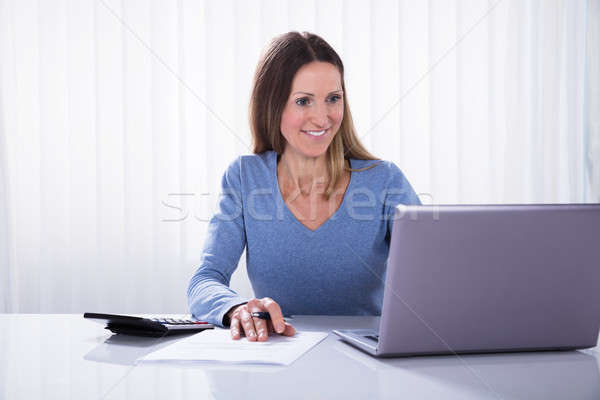 Happy Businesswoman Looking At Laptop Stock photo © AndreyPopov