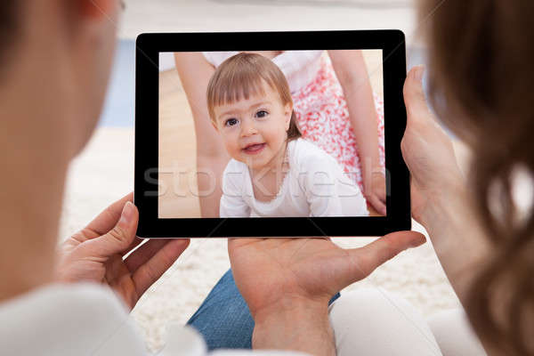 Couple Looking At Image Of Baby Stock photo © AndreyPopov