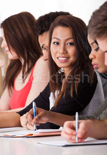 Weiblichen Studenten Sitzung Klassenkameraden schriftlich Schreibtisch Stock foto © AndreyPopov
