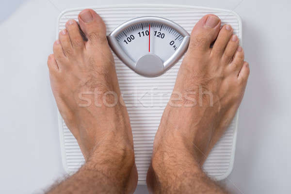 Man Standing On Weight Scale Stock photo © AndreyPopov