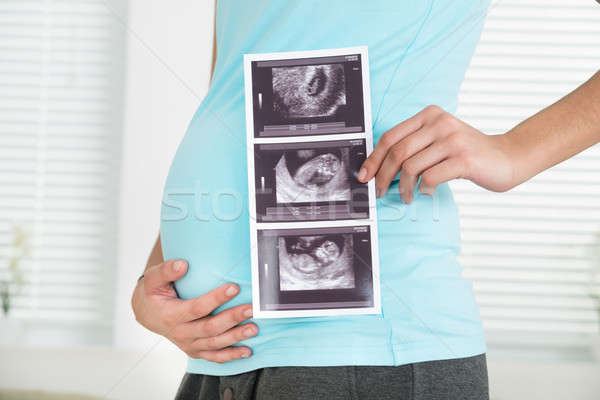 Midsection Of Pregnant Woman Holding Ultrasound Scan Stock photo © AndreyPopov