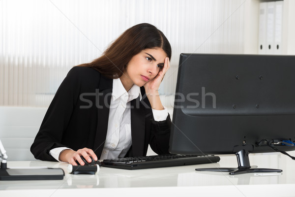 Stressed Young Businesswoman Using Computer At Desk Stock photo © AndreyPopov
